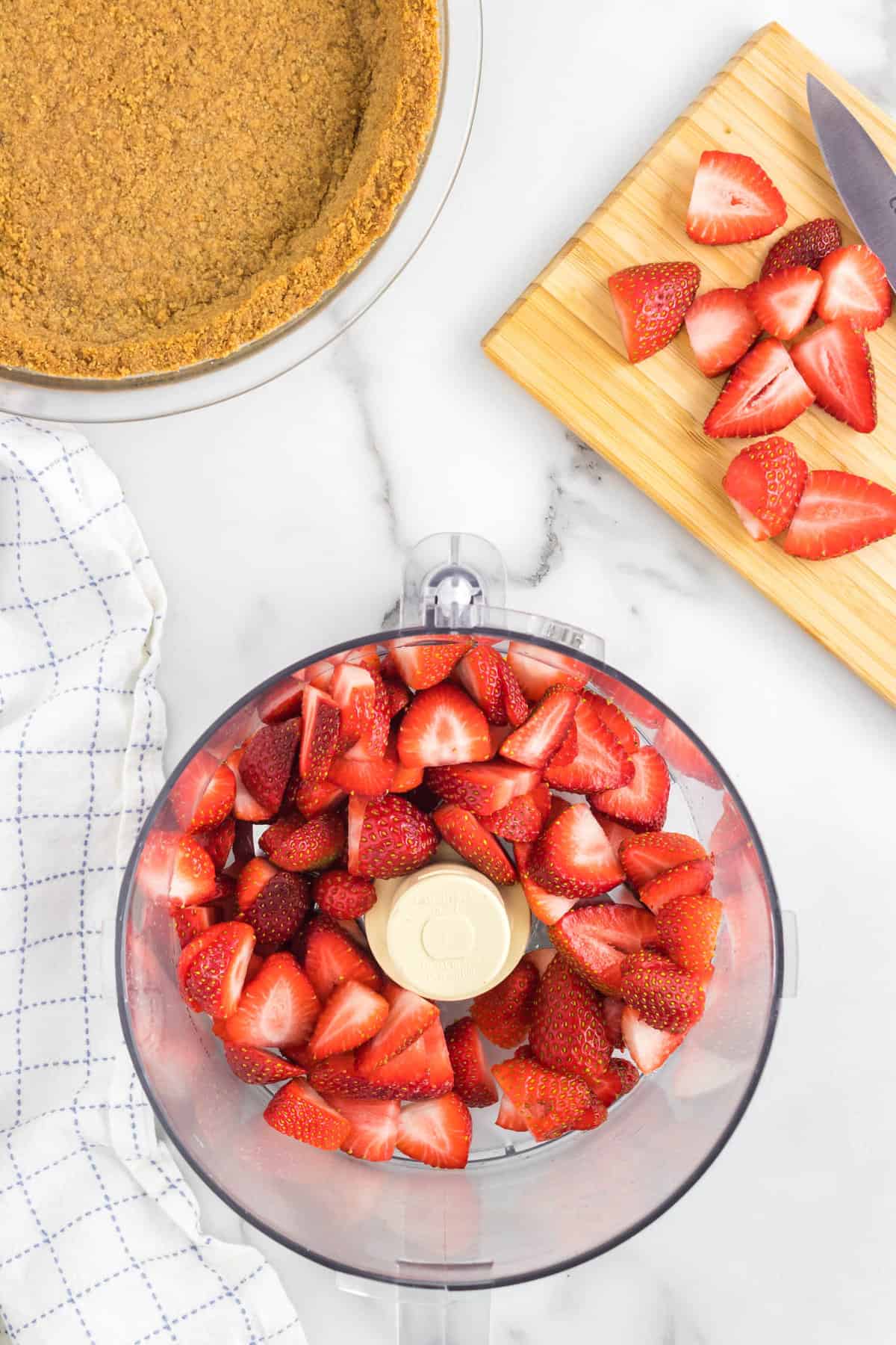 Washed and Sliced Strawberries in Food Processor for No Bake Strawberry Cheesecake Recipe