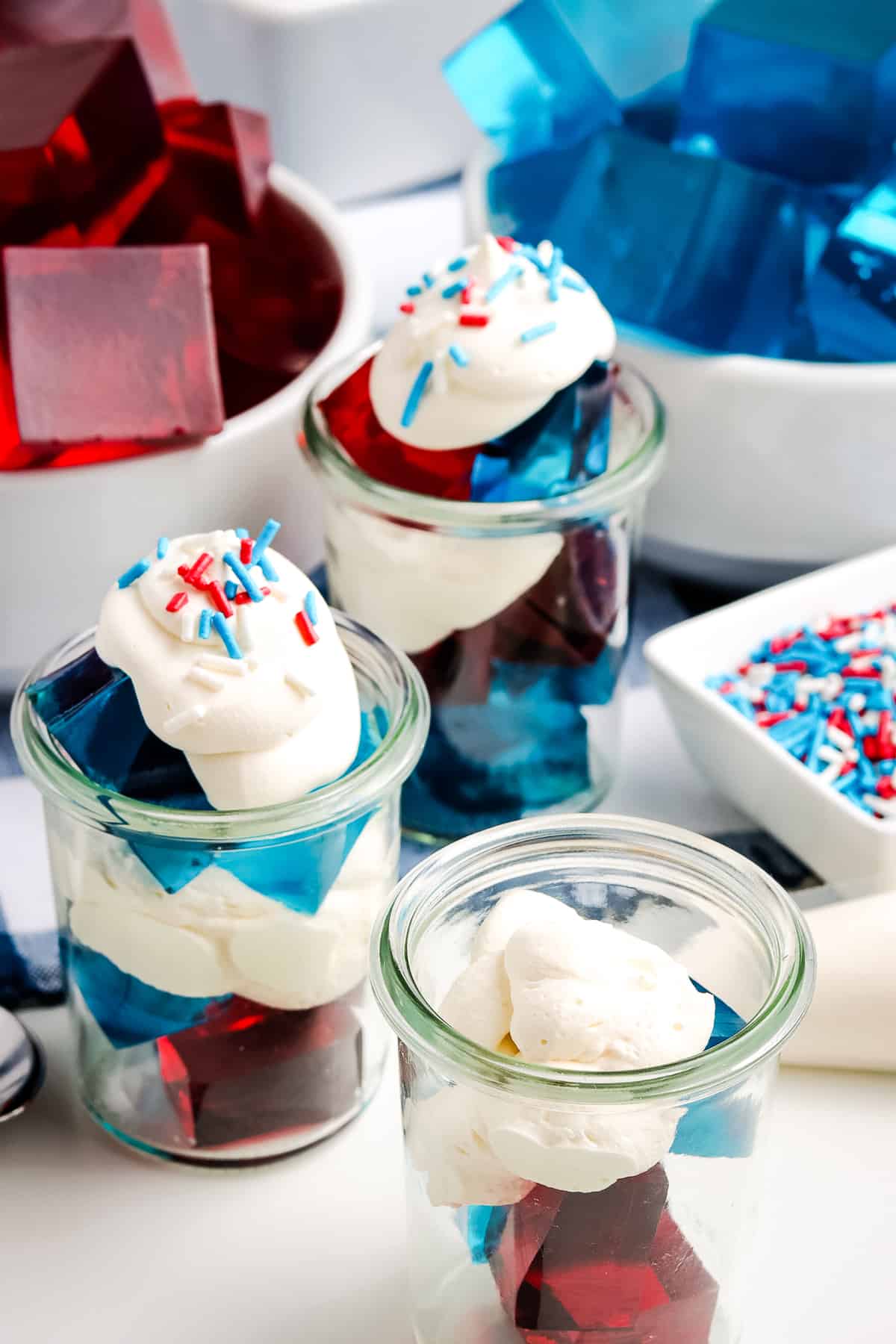 Photo of putting layers of jello, whipping cream and sprinkles in a cup