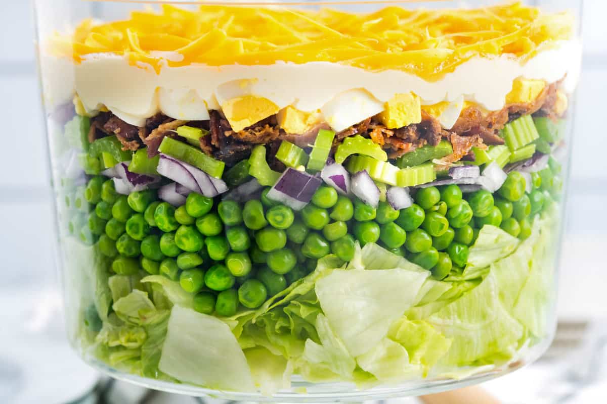 Close up image of Seven Layer Salad in glass trifle bowl showing layers