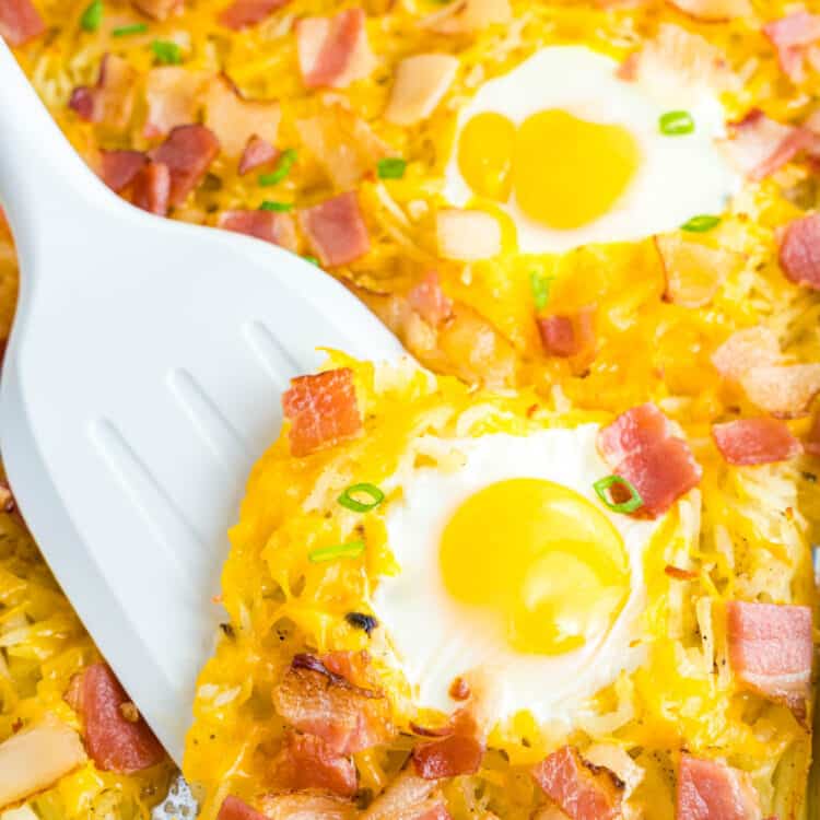 Spoon scooping an egg off a sheet pan breakfast