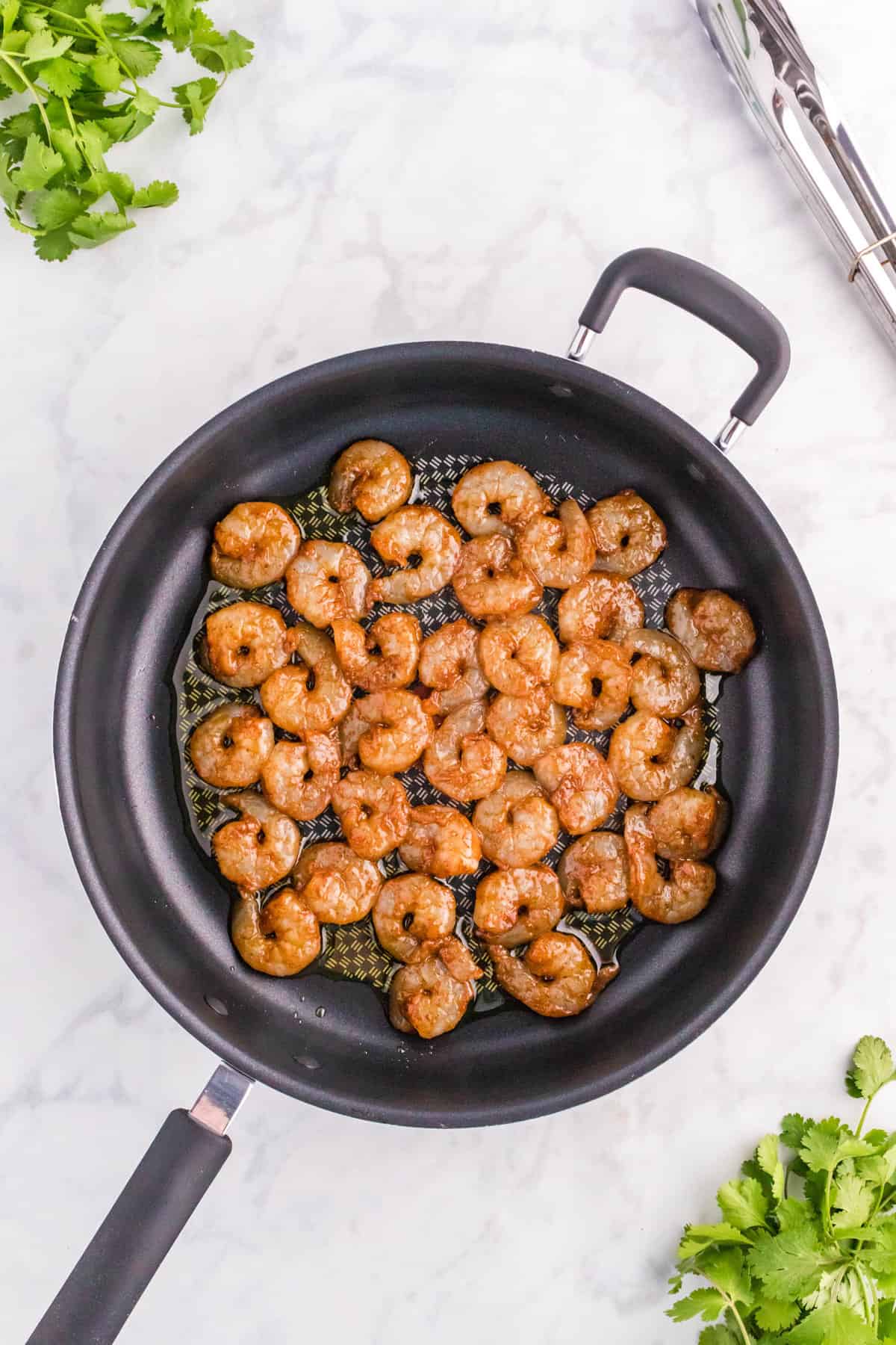 Tossing Seasoned Shrimp in Olive Oil for Shrimp Tacos Recipe