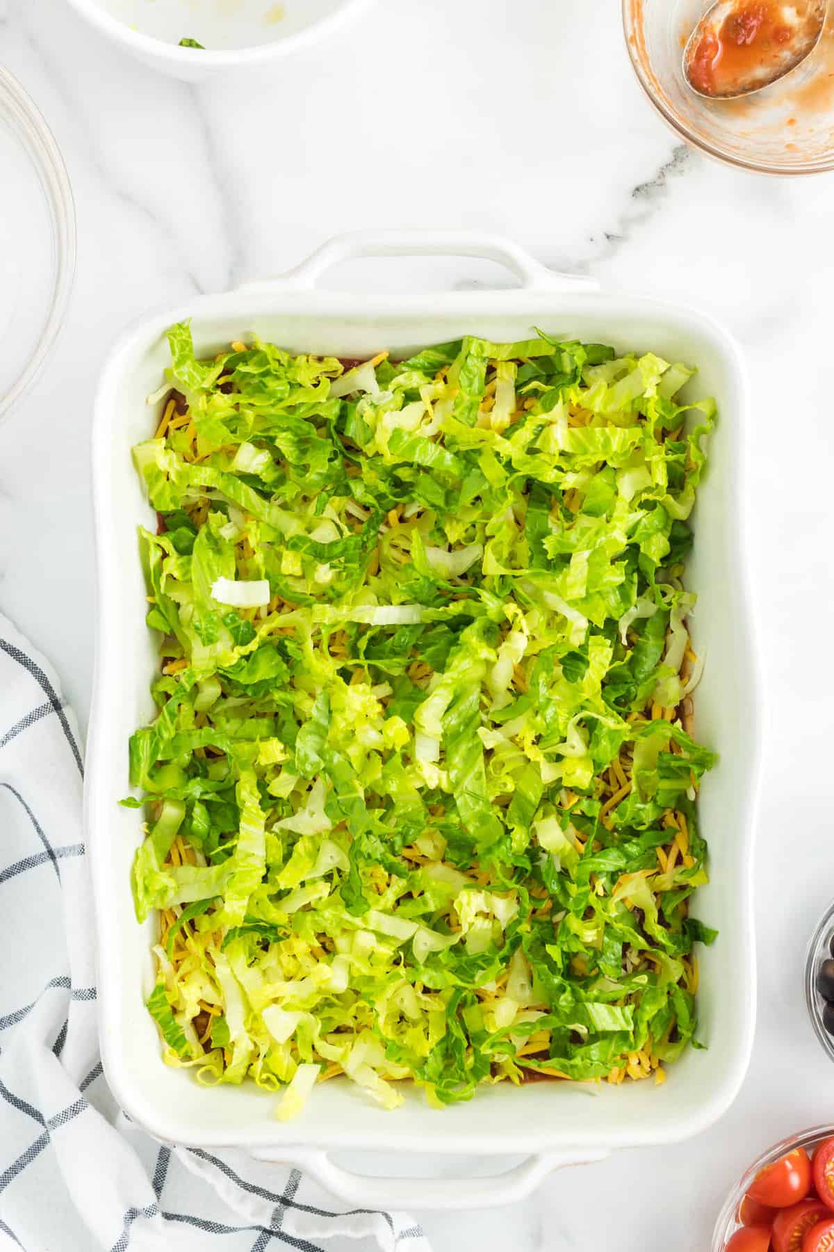 Adding Shredded Lettuce to Easy Taco Dip in 9x13 Pan