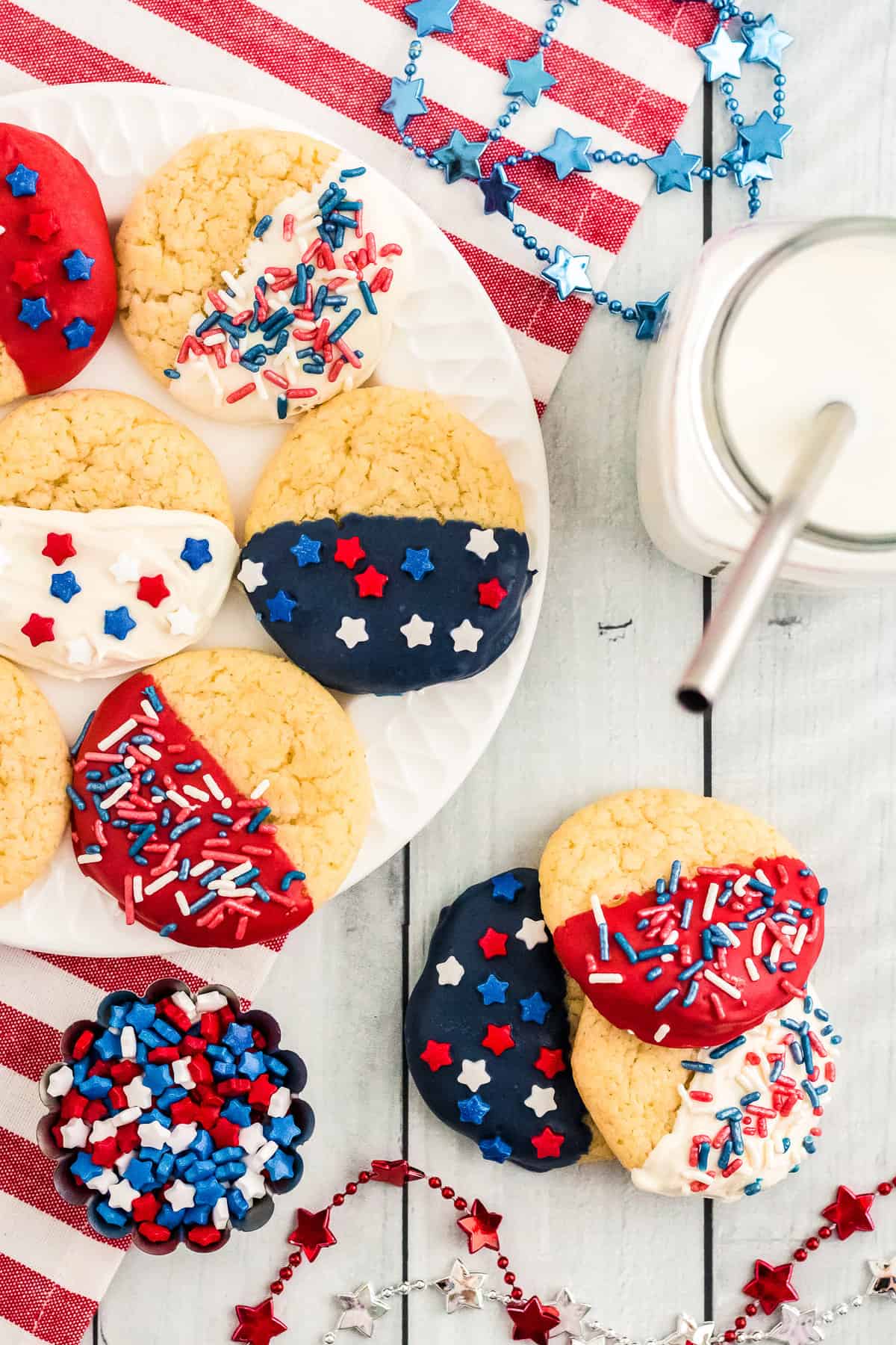 a bunch of cookies displayed on a plate and the table with a cup of milk