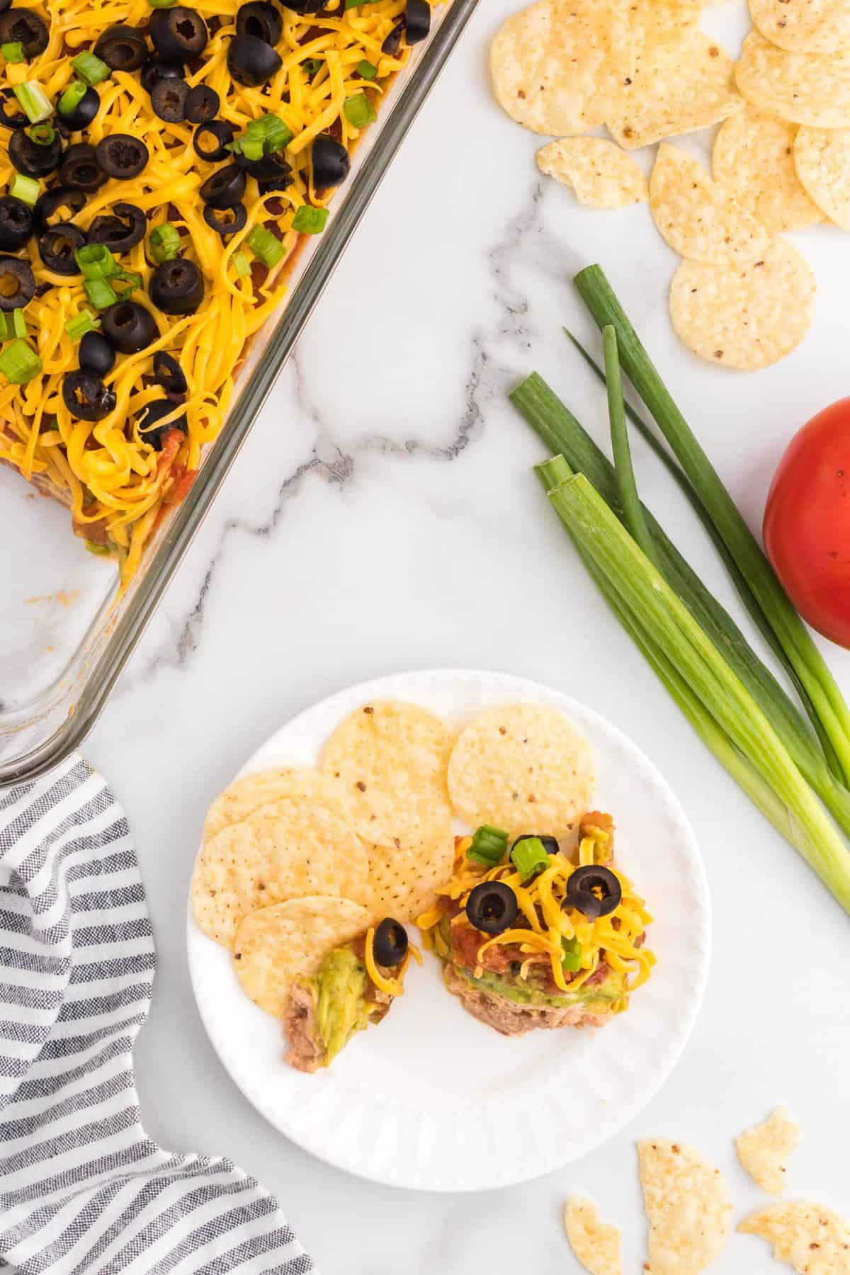 Plate of tortilla chips and 7 layer dip
