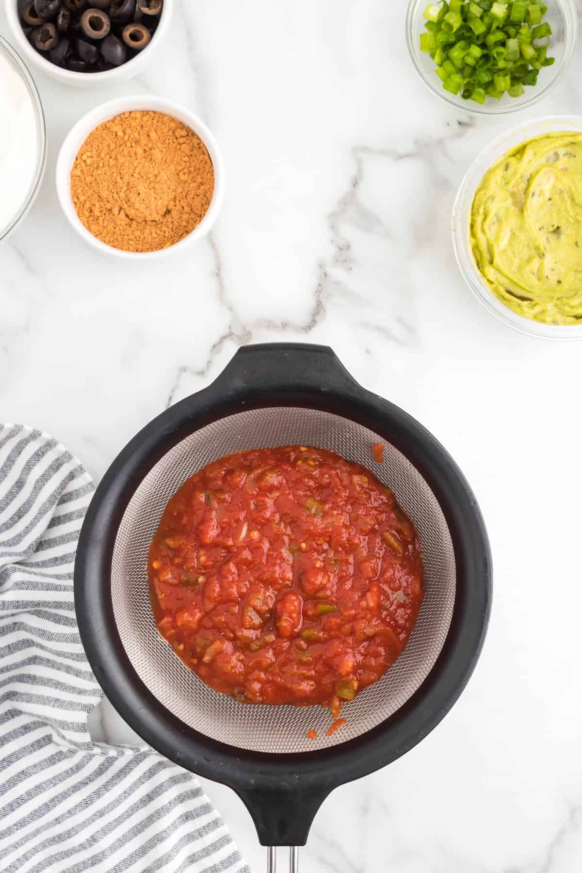 Straining salsa for 7 Layer Dip