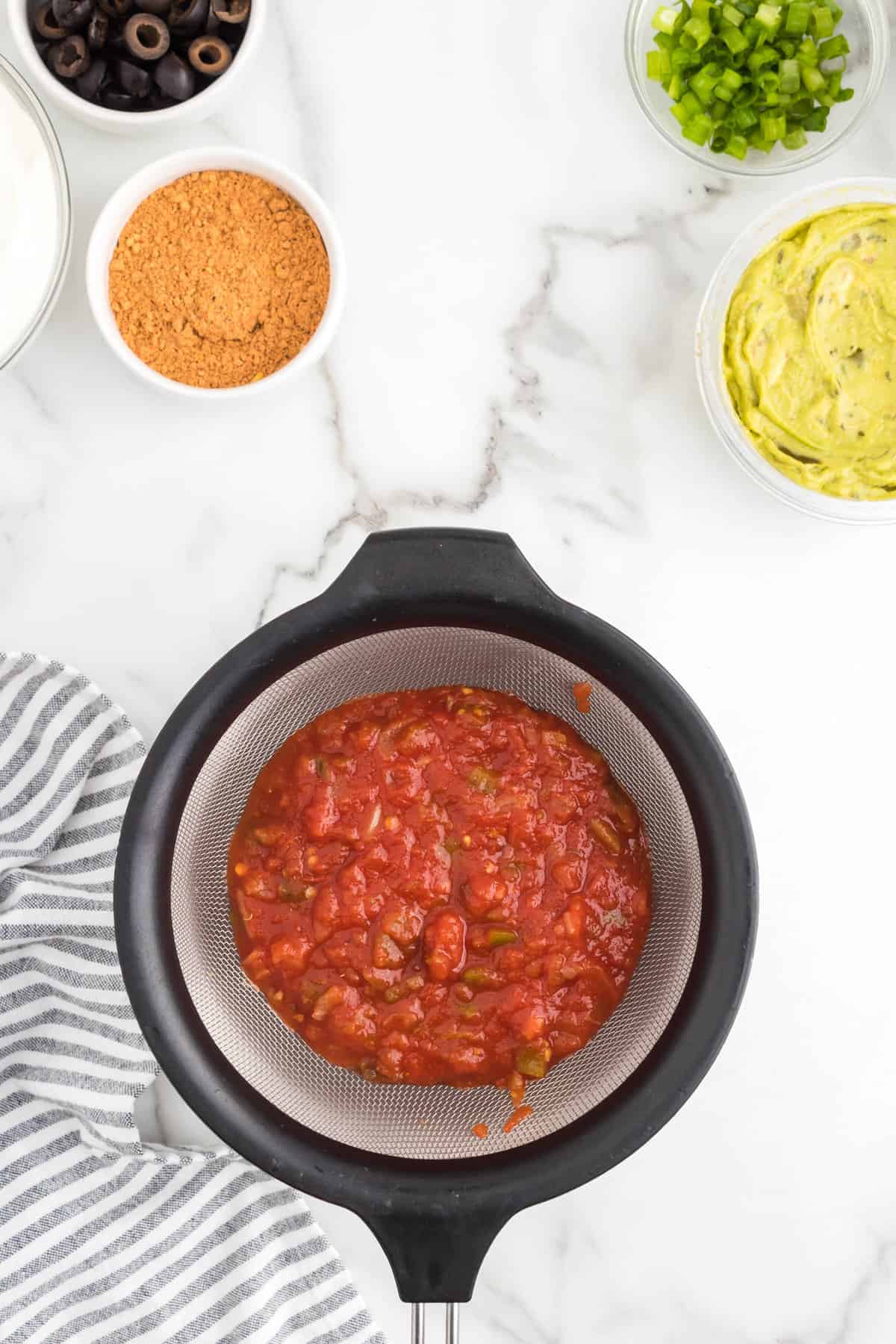 Straining salsa for 7 Layer Dip 