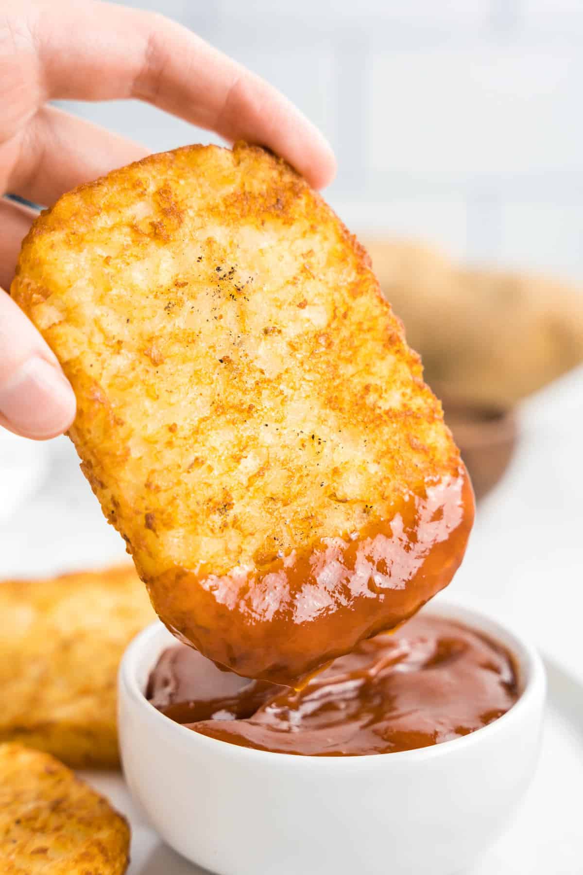 Frozen Hash browns in air fryer dipped in ketchup