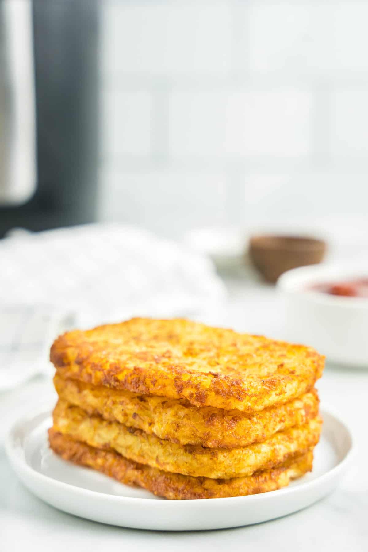 Air Fryer Hash Brown Patties Stacked on Plate Ready to Enjoy
