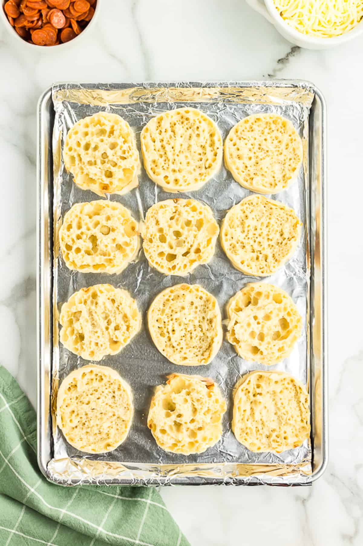 Cut English Muffins in half, toast them & put then on a baking sheet.