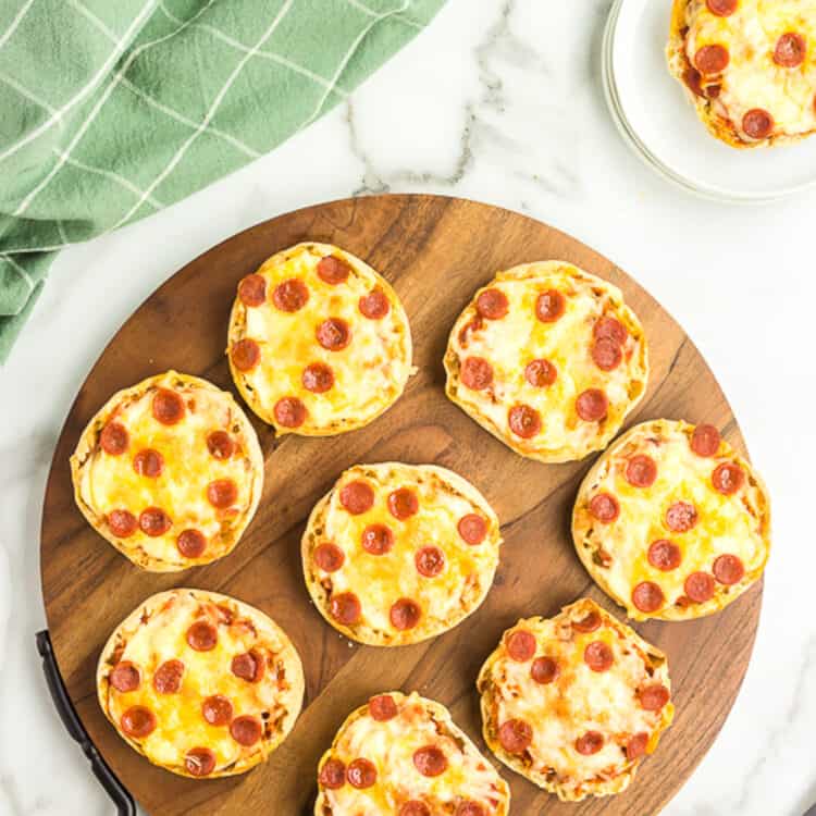 Photo of Pizzas displayed on a wooden pizza sheet.