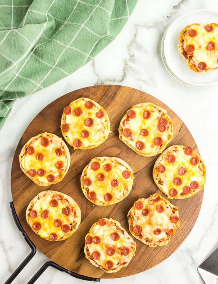 Photo of Pizzas displayed on a wooden pizza sheet.