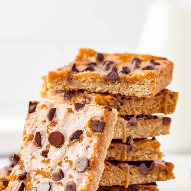 Ooey gooey Caramel Oatmeal Bars stacked with one bite