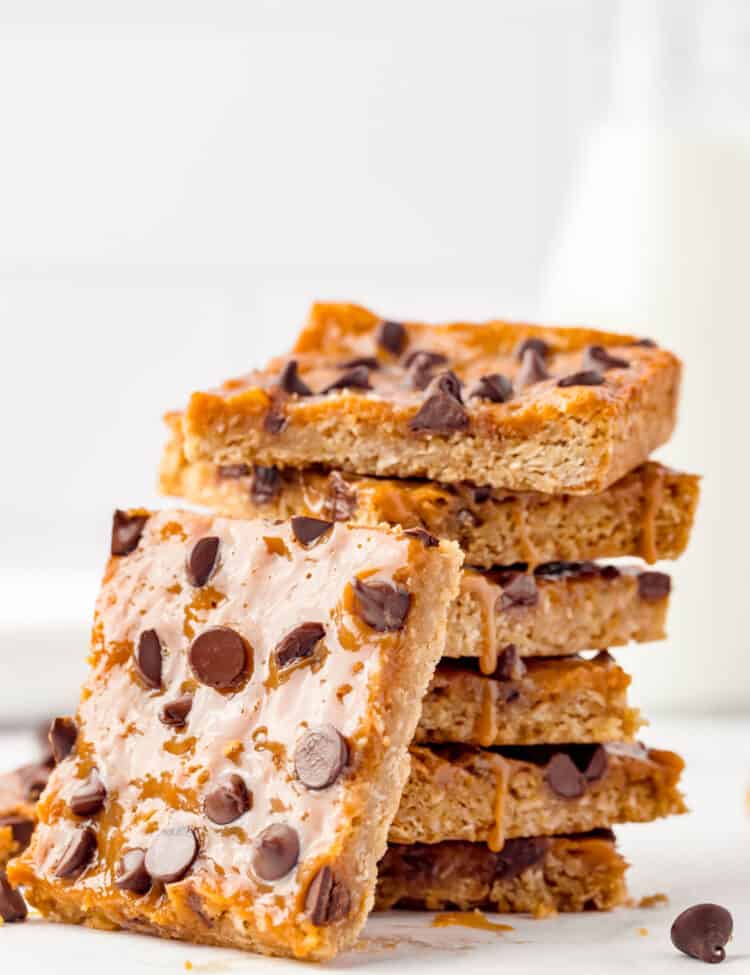Ooey gooey Caramel Oatmeal Bars stacked with one bite