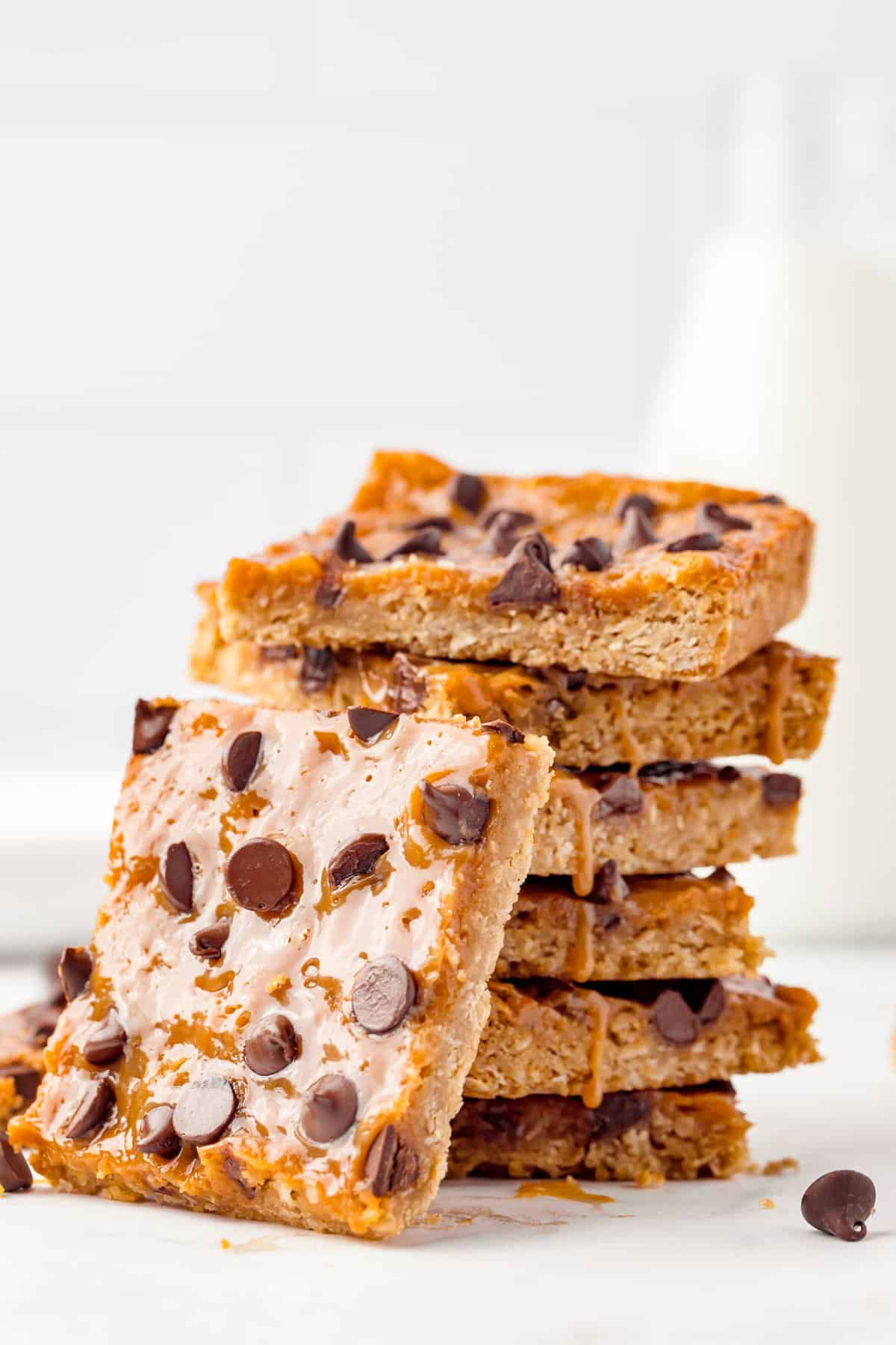 Ooey gooey Caramel Oatmeal Bars stacked with one bite