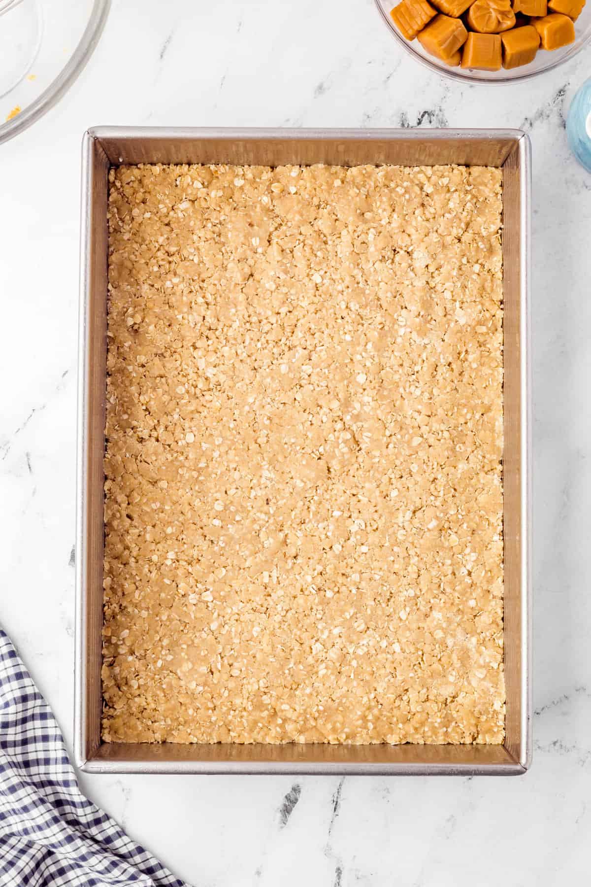 Pressing crust into pan for Caramel Oatmeal Bars