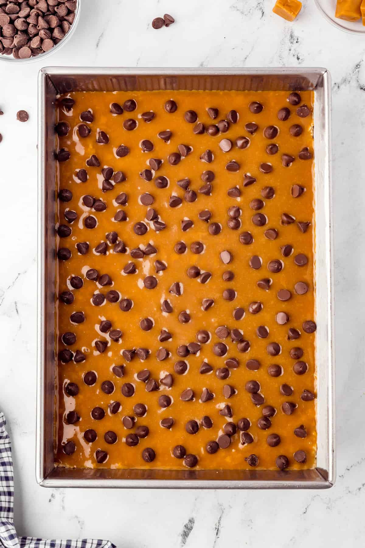 Adding chocolate chips over caramel for Caramel Oatmeal Bars