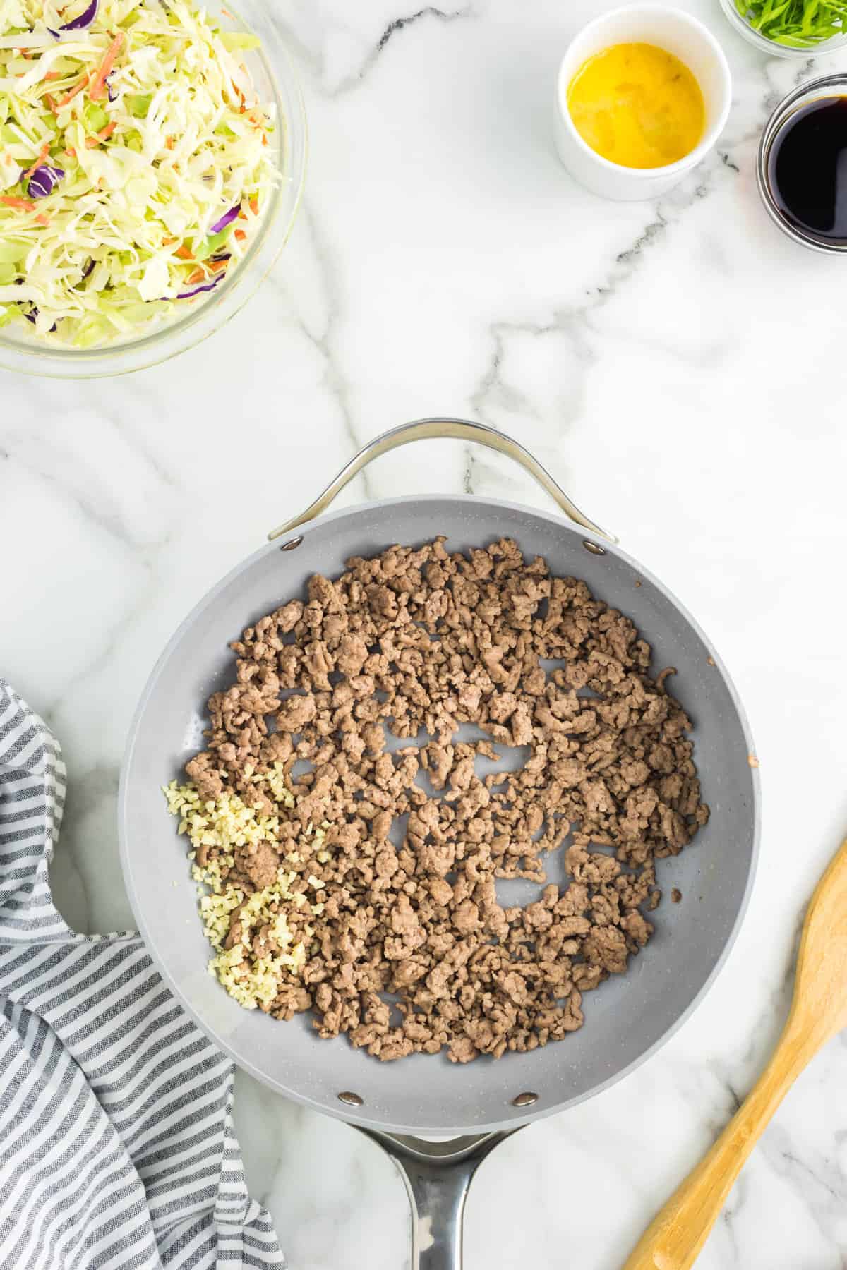 Cooking ground beef or pork with garlice in stovetop pan for Egg Roll in a Bowl Recipe