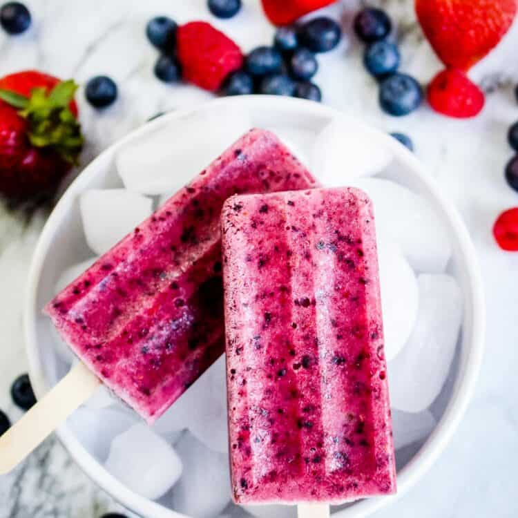 Photo of two Completed Berry Popsicles on a Bowl of Ice