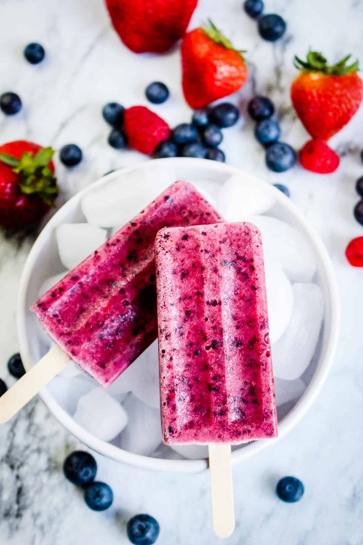 Photo of two Completed Berry Popsicles on a Bowl of Ice