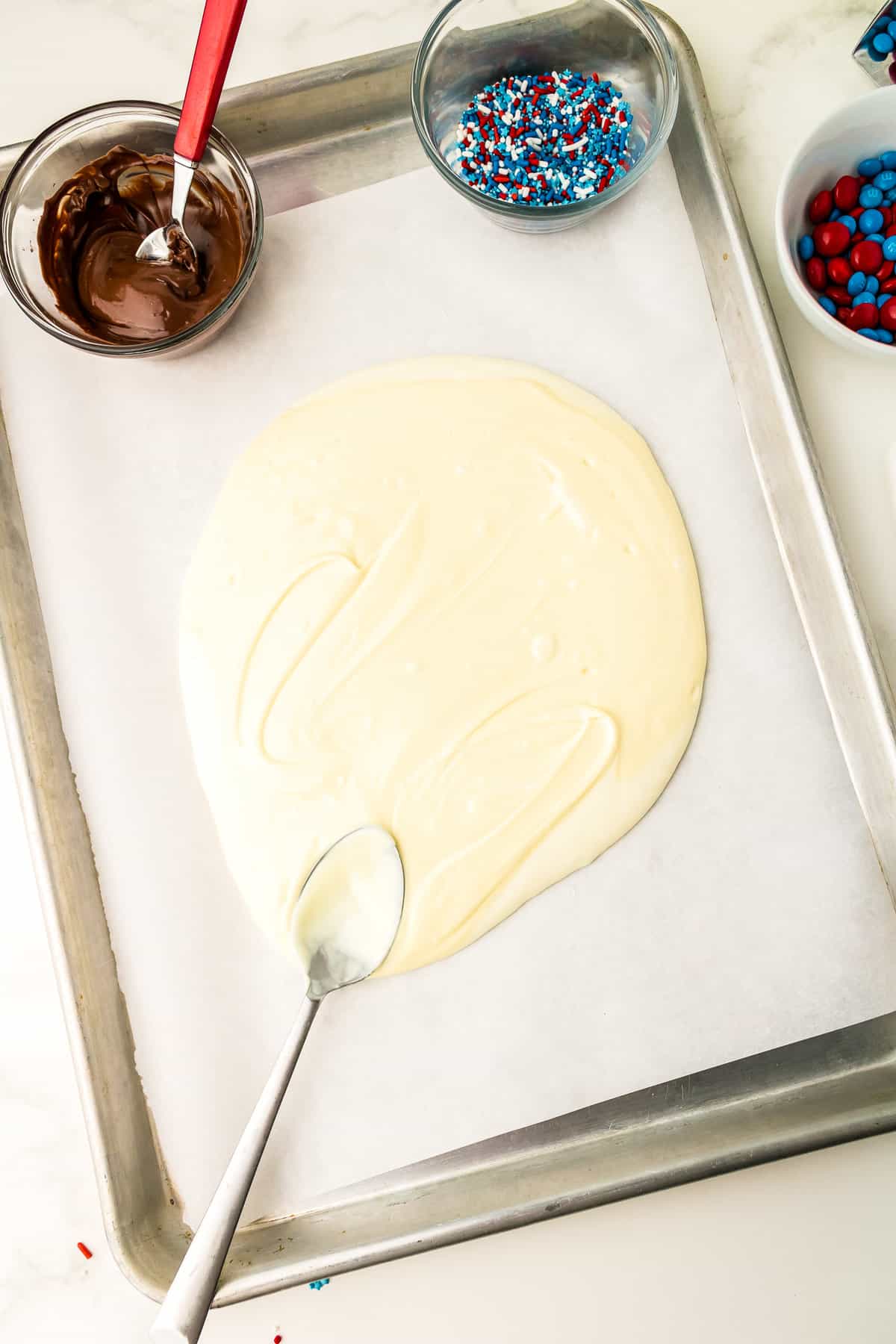 Pour White Chocolate onto a pan with Parchment Paper and spread out.