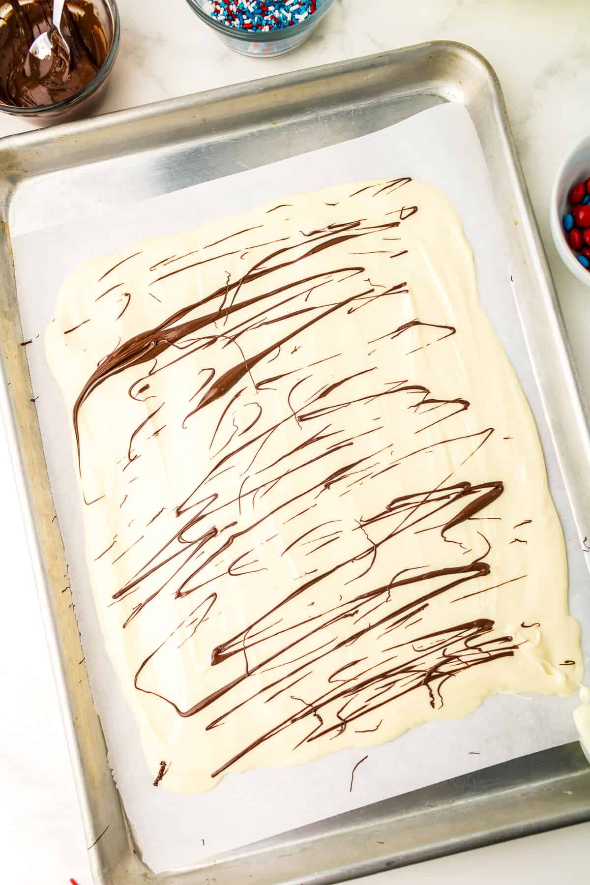 Melt Chocolate Chips and drizzle over the white chocolate.