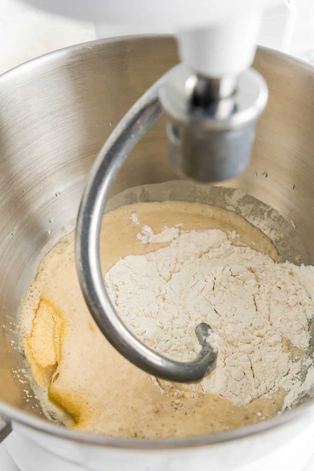 Adding water, yeast and sugar in a mixing bowl for Easy Homemade Pizza Dough