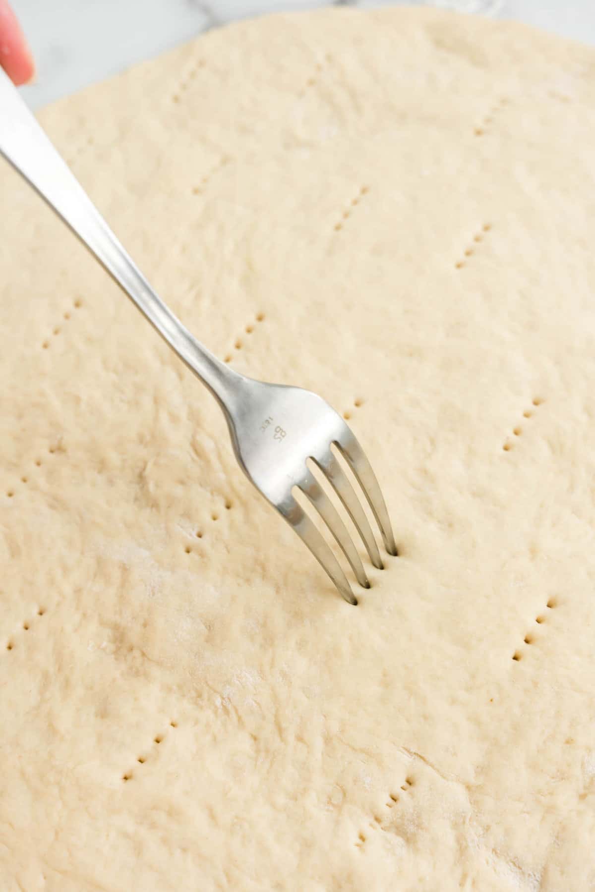 Using Fork to Poke Crust for Homemade Pizza Recipe