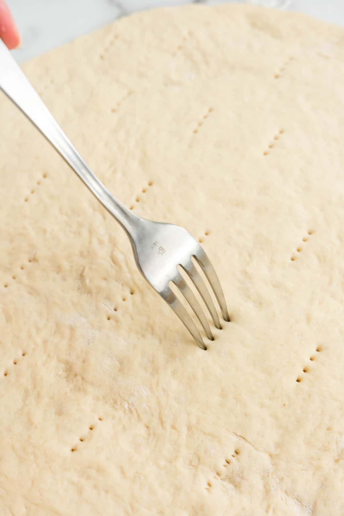 Piercing Homemade Pizza Dough with Fork