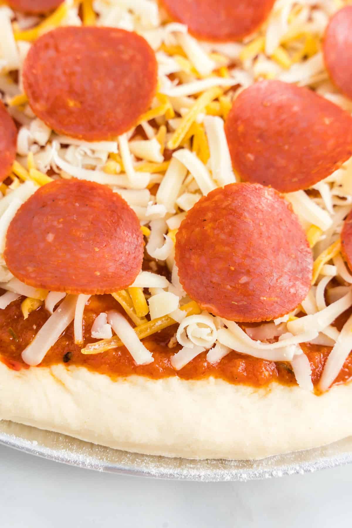 Adding Cheese and Pepperoni Toppings for Homemade Pizza