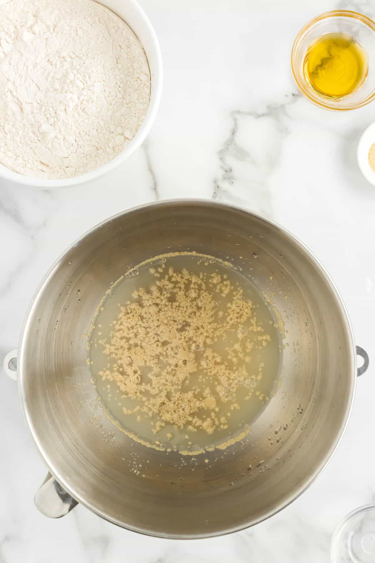 Combining warm water, sugar, and yeast in mixing bowl for Easy Homemade Pizza Dough