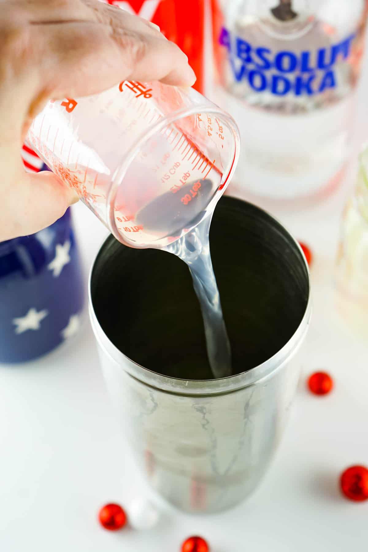 Pouring lemonade into shaker for Red, White and Blue Cocktail