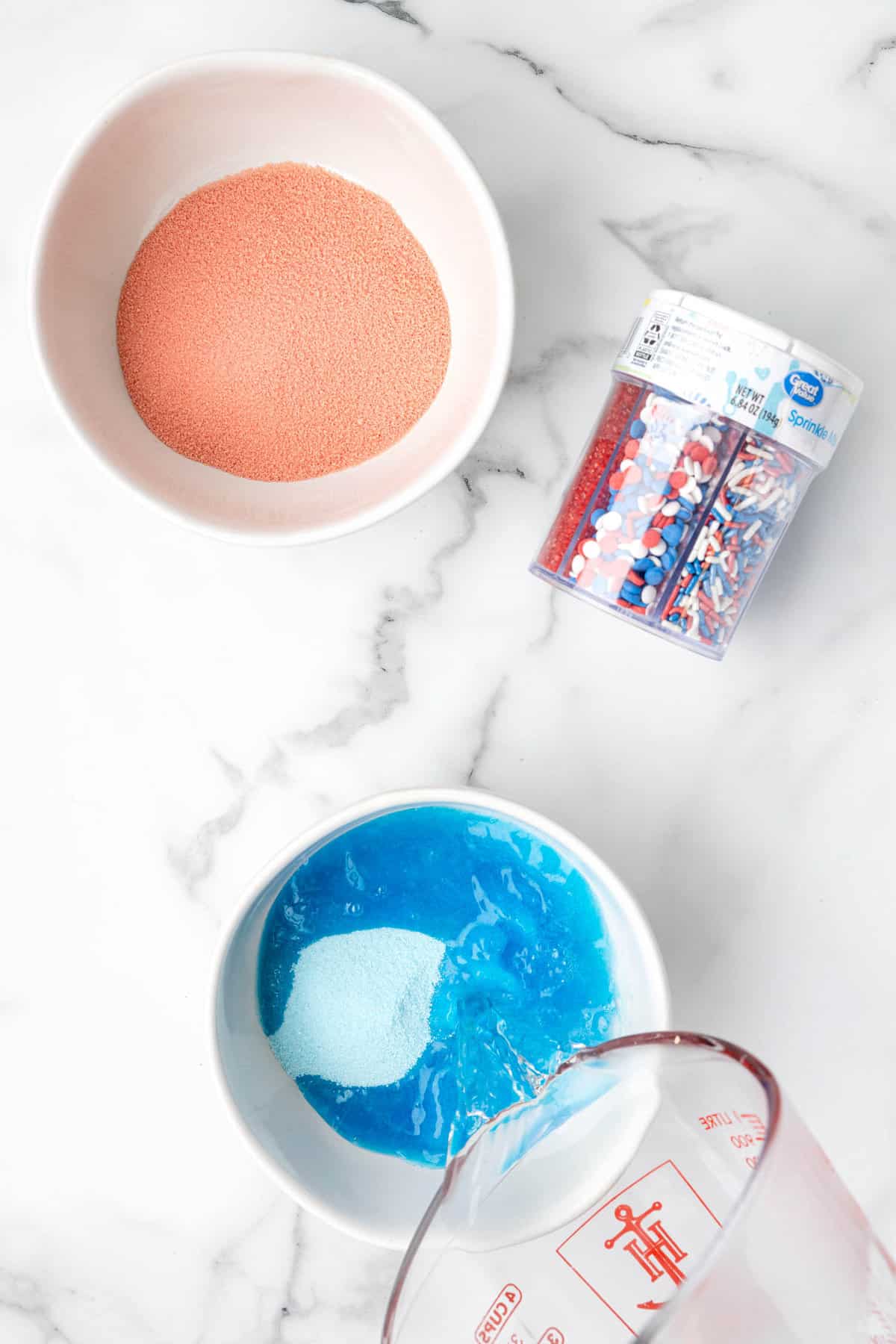 Adding boiling water to blue jello for mixing for the Red White and Blue Jello Cake recipe