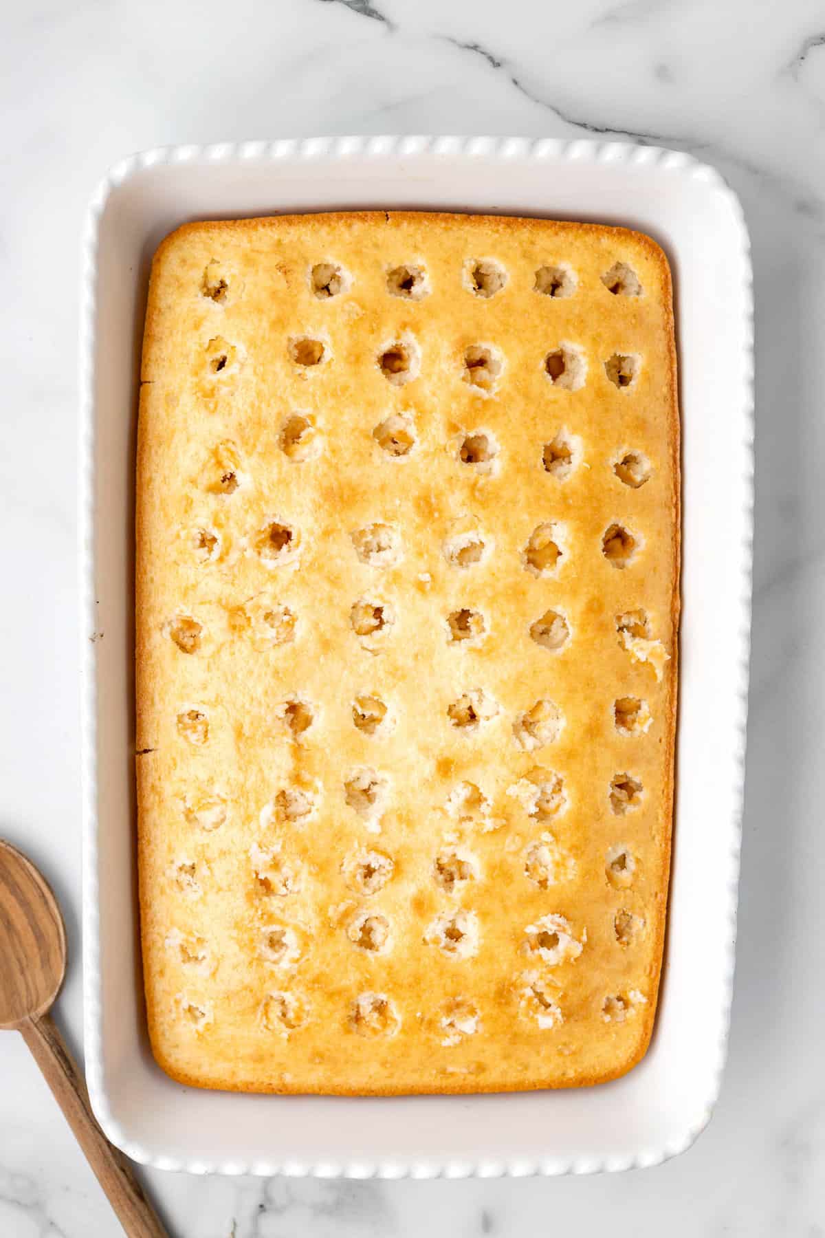 Holes in baked white cake for Fourth of July Poke Cake
