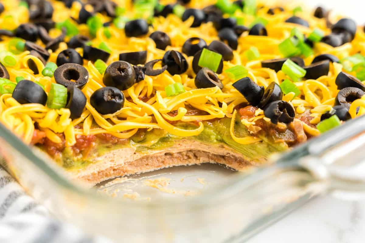 Seven Layer Dip showcasing the layers in glass serving dish