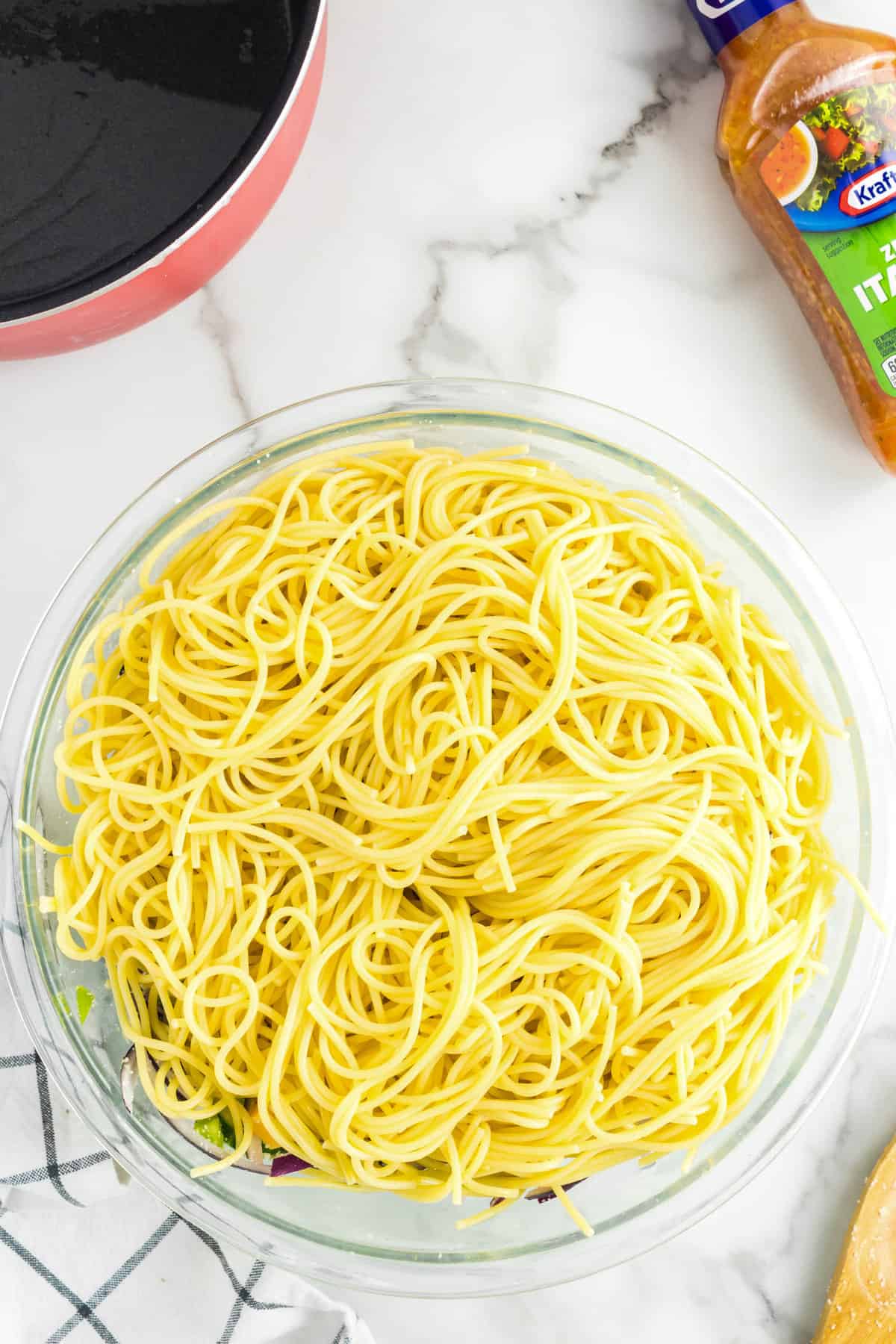 Adding cooked spaghetti to ingredients for Simple pasta salad recipe
