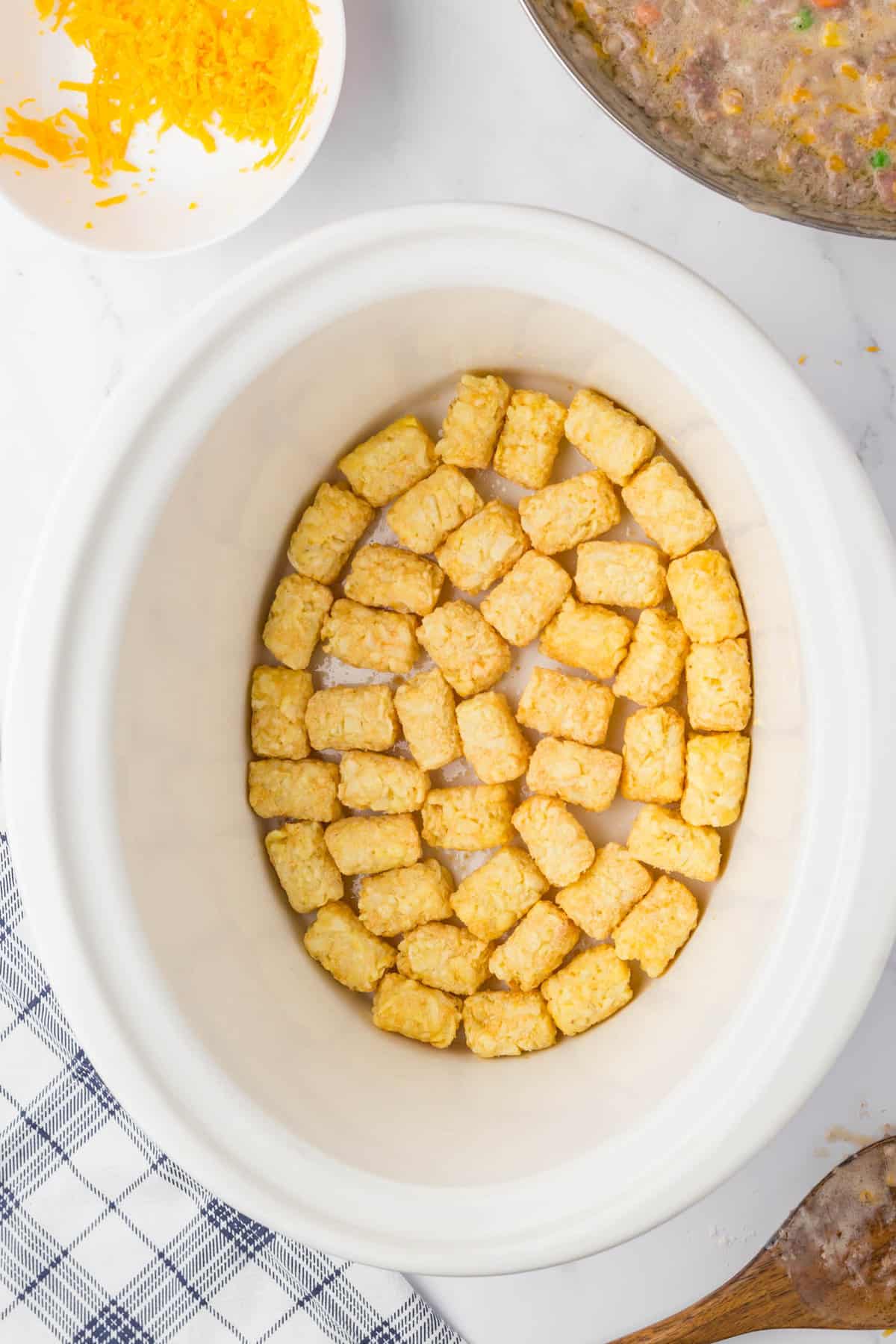 Lining bottom of crock pot with tator tots for Bacon Cheeseburger Crock Pot Tater Tot Casserole