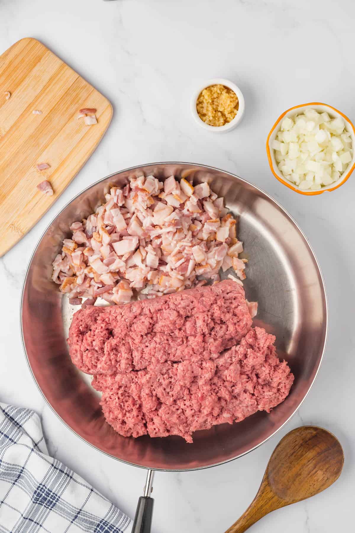 Ground beef and chopped bacon in stovetop skillet ready to brown for Bacon Cheeseburger Crock Pot Tater Tot Casserole