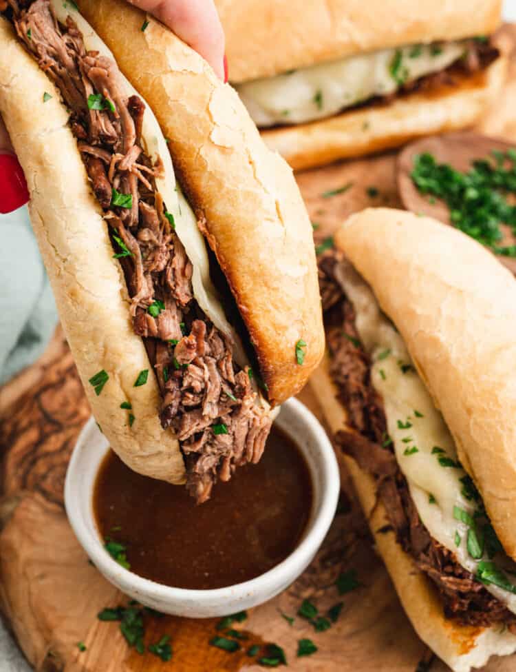 French Dip Sandwich dipping in au jus.