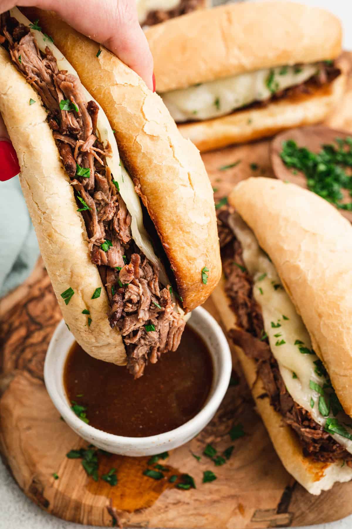 French Dip Sandwich dipping in au jus.