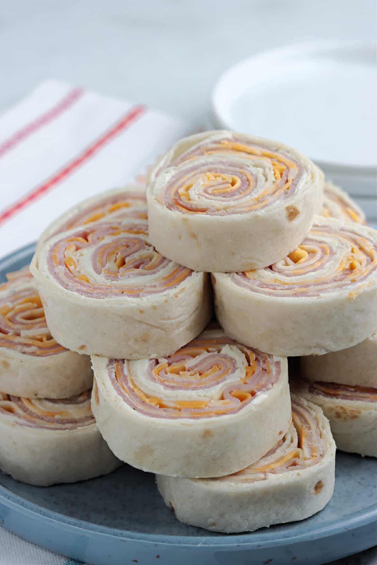 a Close up Picture of Ham and Cheese Rollups stacked on top of one another.