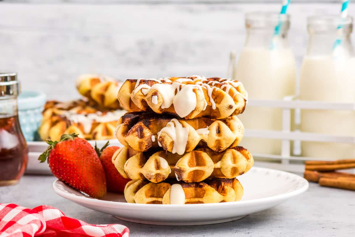 Cinnamon Roll Waffles Stacked in four on a plate.