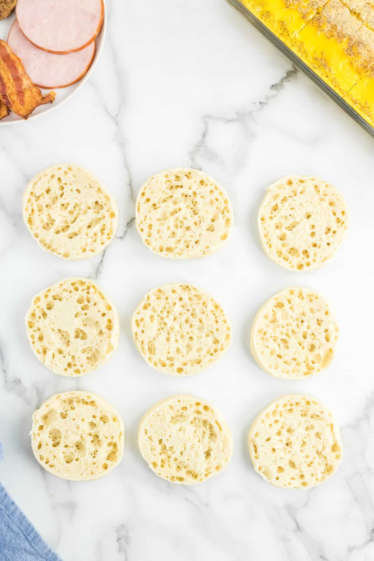 Sliced open facing English muffins for Freezer Breakfast Sandwiches