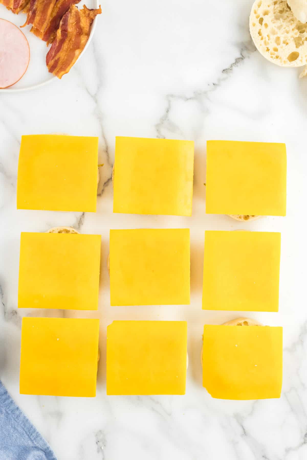 Topping eggs with sliced Cheddar cheese for Frozen Breakfast Sandwiches