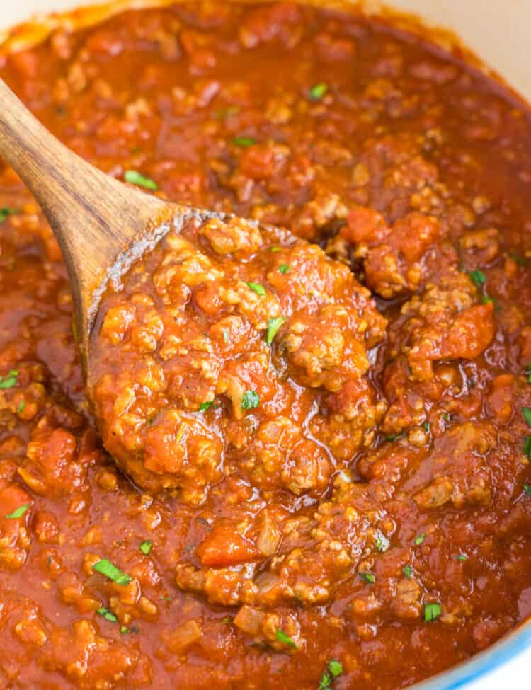 Homemade Spaghetti Sauce Recipe in Stovetop Pot with Wooden Spoon Stirring