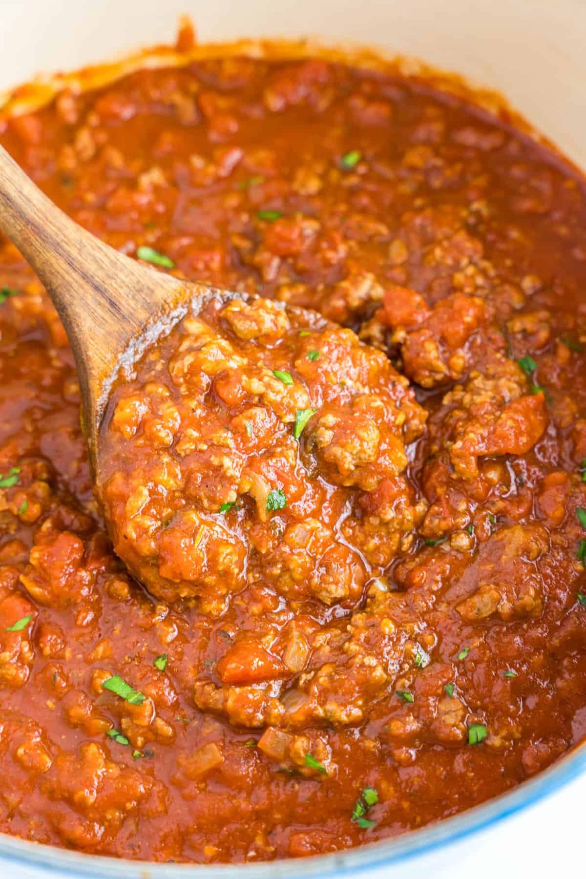 Homemade Spaghetti Sauce Recipe in Stovetop Pot with Wooden Spoon Stirring