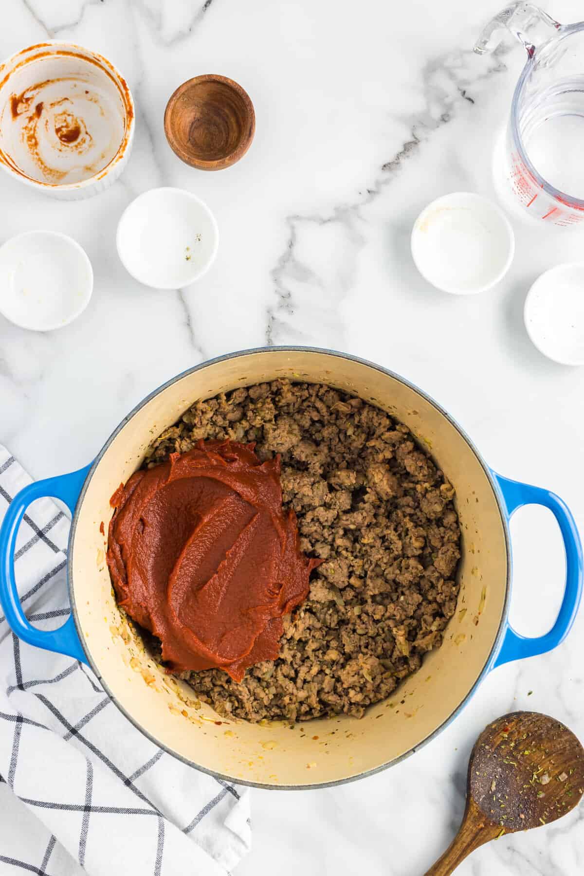 Adding tomato paste to seasoned meat mixture for Homemade Pasta Sauce