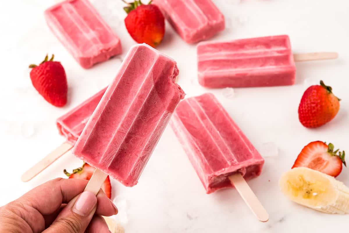 Picture of a Bite taken out of One Popsicle with Other Popsicles in the Back Ground