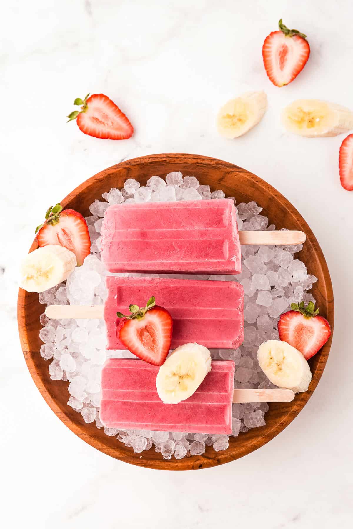 Photo of Popsicles laying on a bowl of Ice.