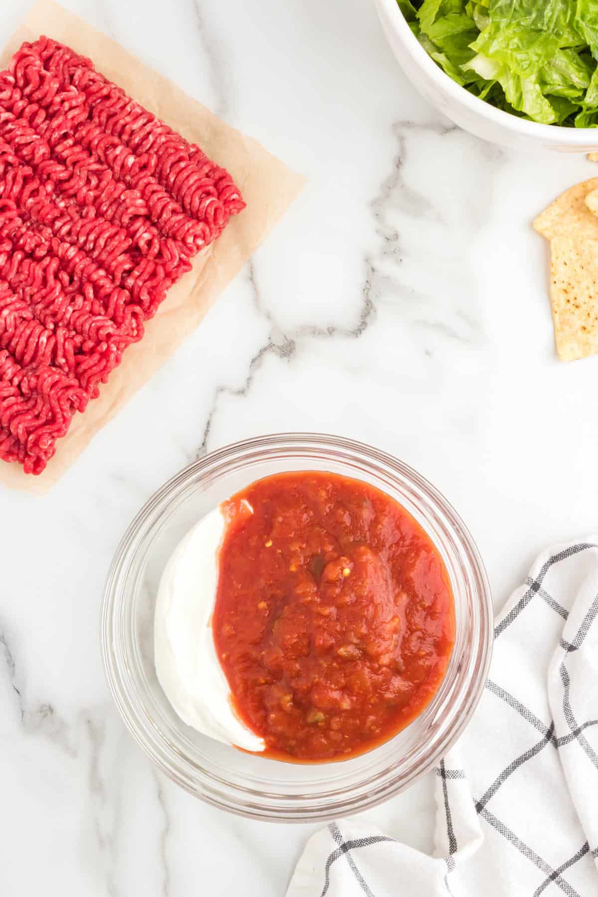 Sour cream and salsa in a bowl ready to combine for taco salad sauce