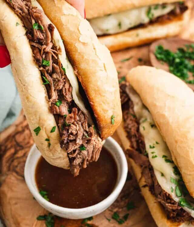 French Dip Sandwich dipping in au jus.
